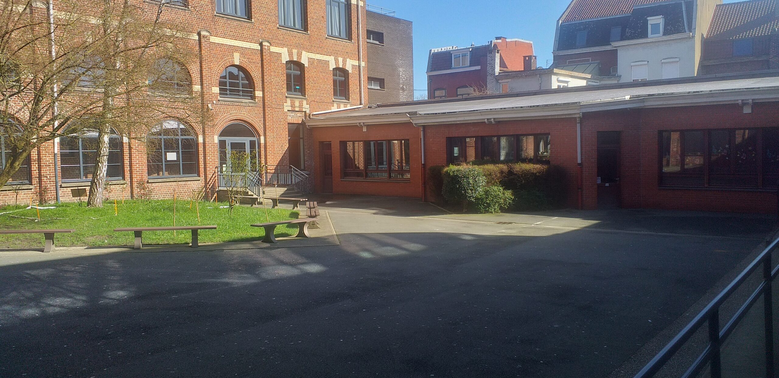 Cour du collège où on aperçoit au fond le bâtiment de la salle de sport.